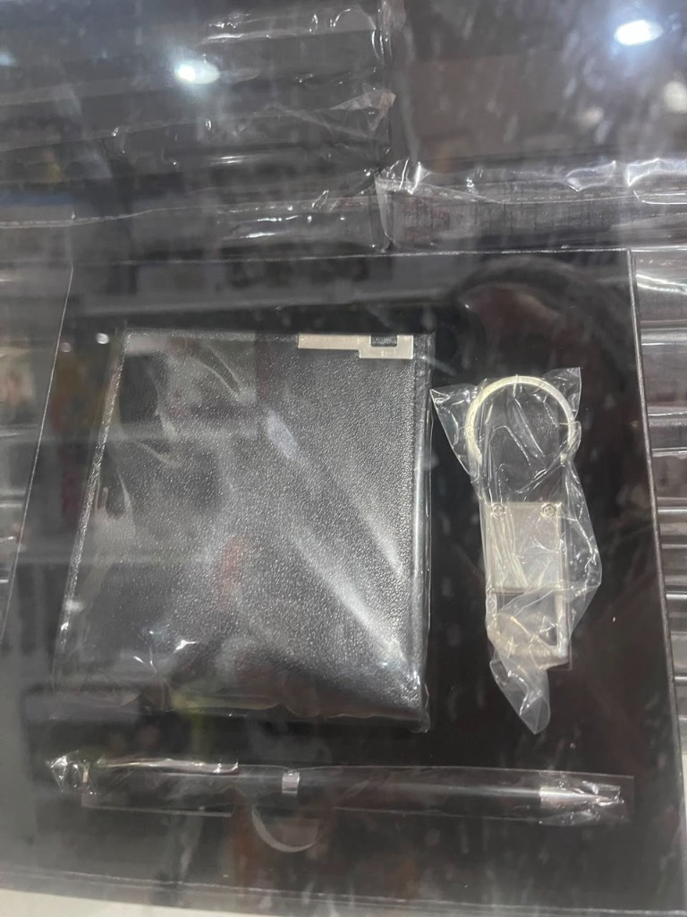 Black wallet, silver keychain, and pen gift set